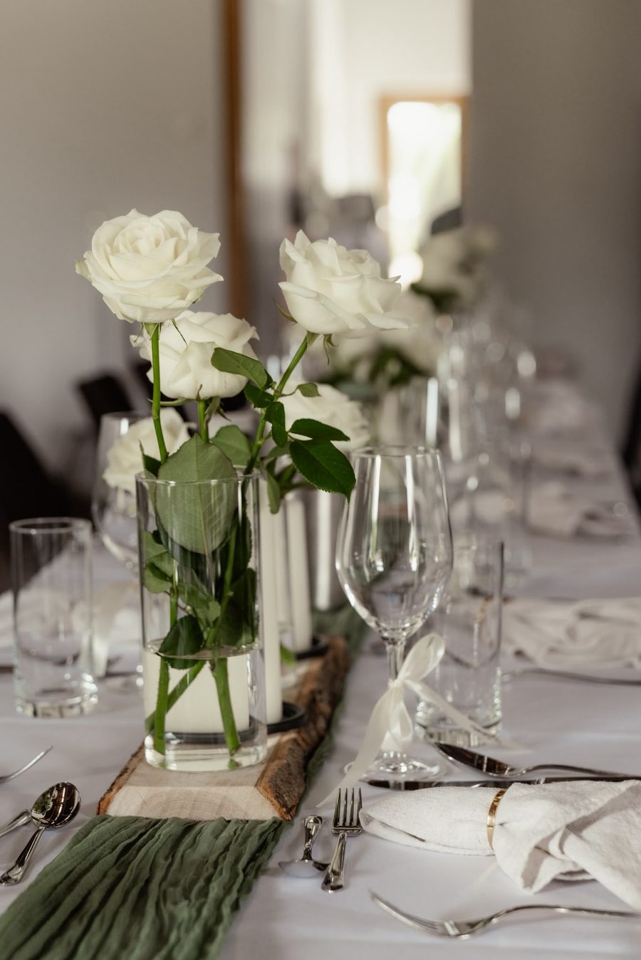 Weiße Rosen und Kerzen als Tischdekoration einer Hochzeit